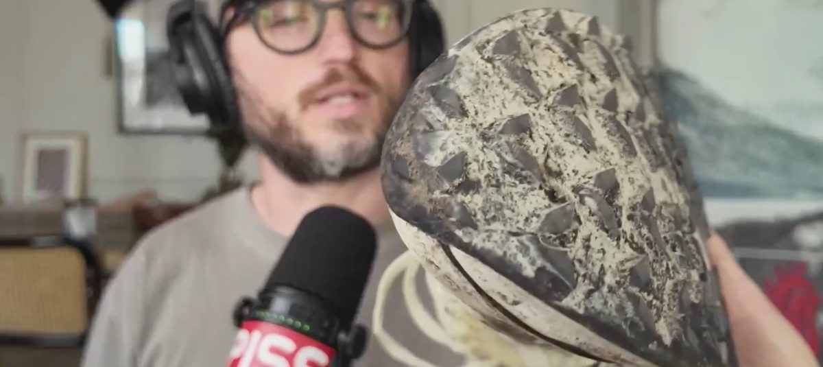 a beautiful man holding a trail running shoe