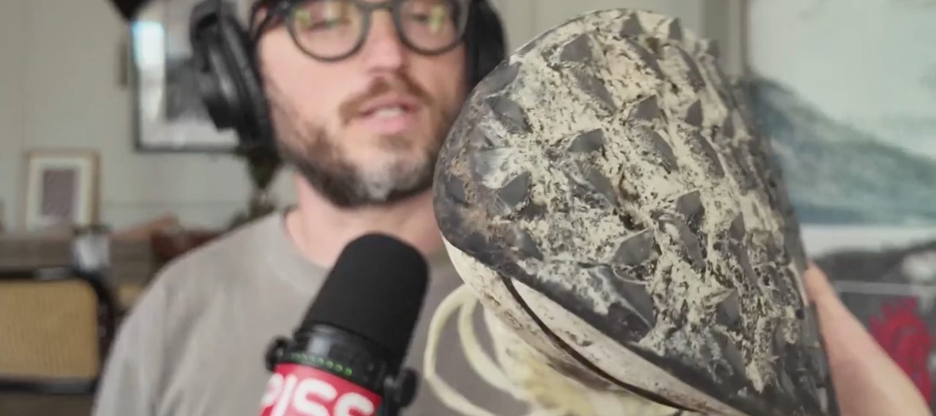 a beautiful man holding a trail running shoe
