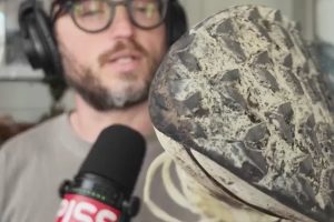 a beautiful man holding a trail running shoe