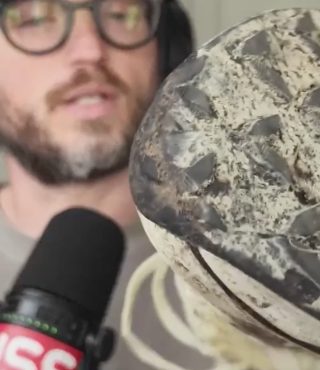 a beautiful man holding a trail running shoe