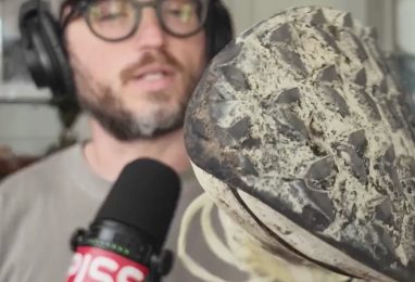 a beautiful man holding a trail running shoe
