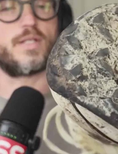 a beautiful man holding a trail running shoe