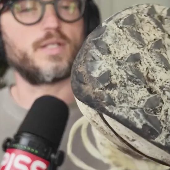 a beautiful man holding a trail running shoe