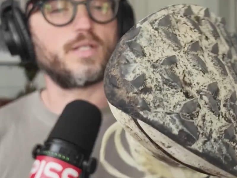 a beautiful man holding a trail running shoe