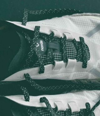 White athletic shoes with black laces - Norda 001a