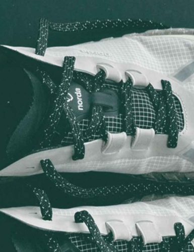 White athletic shoes with black laces - Norda 001a