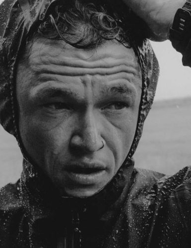 Man in raincoat, serious expression. Matt Johnson.