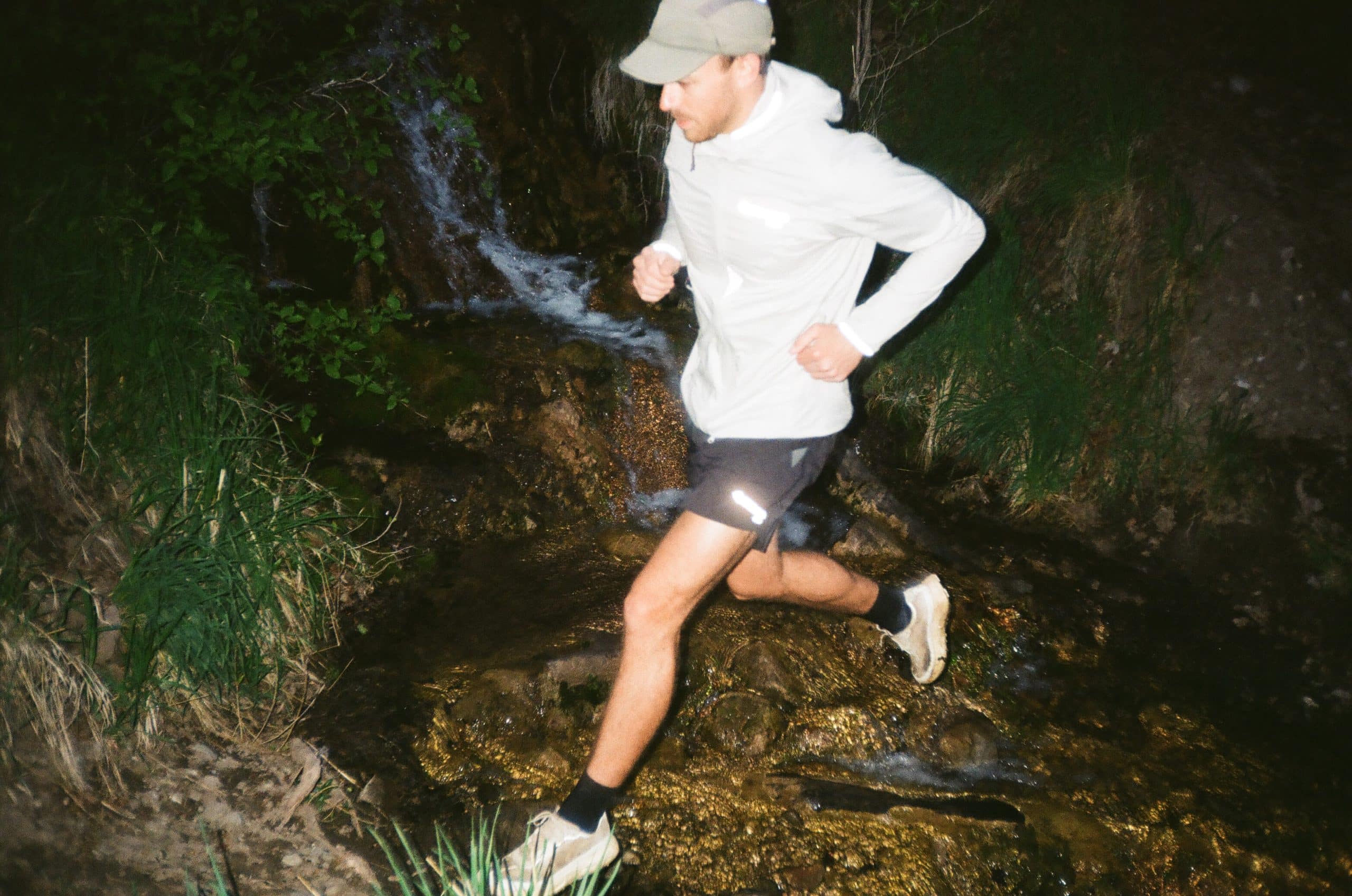 Klättermusen Runner crossing a stream at night.
