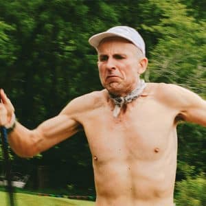 Shirtless runner Harvey Lewis in nature, intense expression
